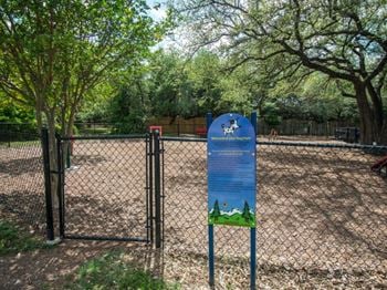 A dog park sign in front of a fence